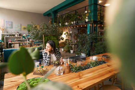 Woman working in studio and looking at windowの写真素材