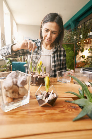 Close-up photo of woman planting flowers in workshopの写真素材