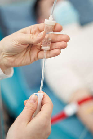 Nurse holding equipment for infusion for man in bedの写真素材