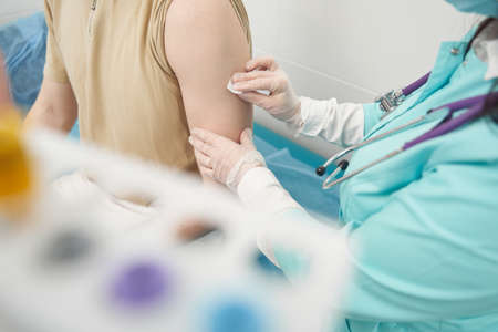 Ma being vaccinated by nurse in hospitalの写真素材