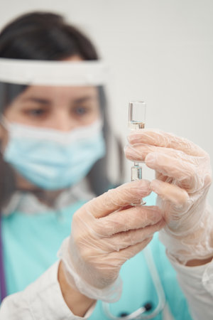 Female doctor preparing medicine for injection in officeの写真素材