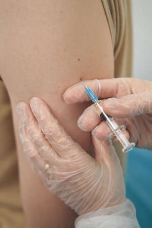 Female medical worker doing vaccination for patientsの写真素材