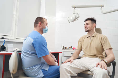 Cheerful man during consultation with doctor in clinicの写真素材