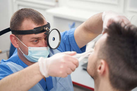 Otorhinolaryngologist during consultation with patient in officeの写真素材