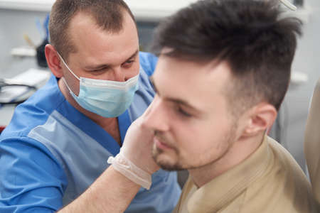 Male doctor seeing young man in officeの写真素材