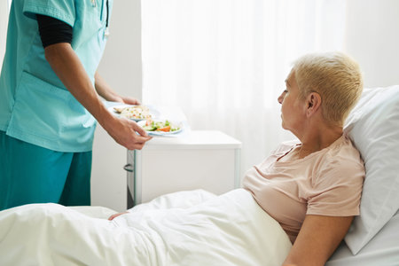 Medical worker bringing meal to aging patient