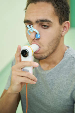 Person taking lung finctionality test with spirometry deviceの写真素材