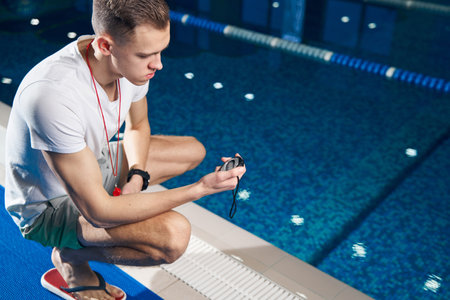 Athletic man looking at the timer in his hand