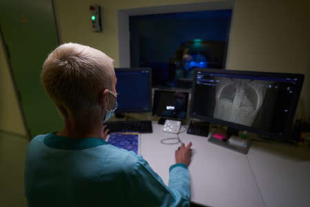 Female doctor examining image of male spine during MRIの写真素材