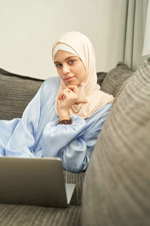 Islamic Arab woman using notebook at home
