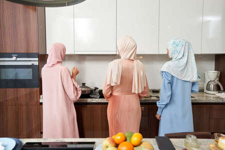 Muslim women cooking dinner in kitchen at homeの写真素材