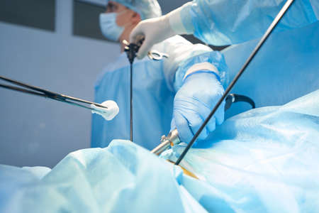 Surgery specialist bringing gauze to abdomen incisionの写真素材