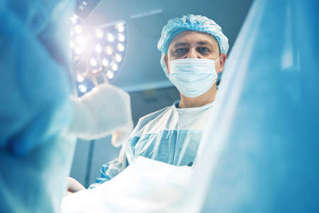 Man surgery expert staring straight during laparoscopic operationの写真素材