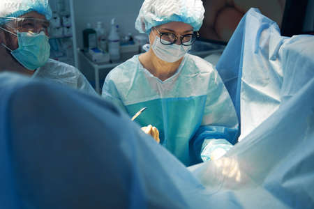Female doctor asking for necessary tool during surgical operation