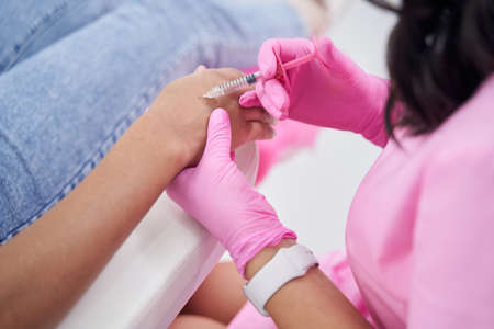 Injection is injected with small syringe into back female handの写真素材