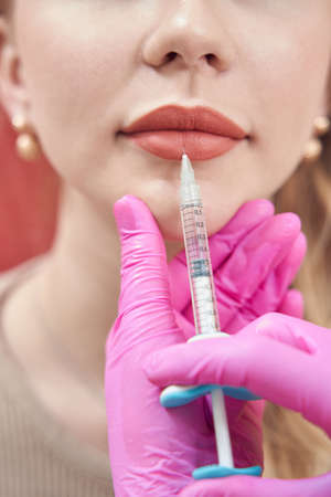 Elegant female client getting cosmetic treatment in cosmetology officeの写真素材