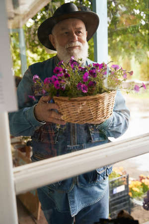 Happy mature florist looking after pot plants