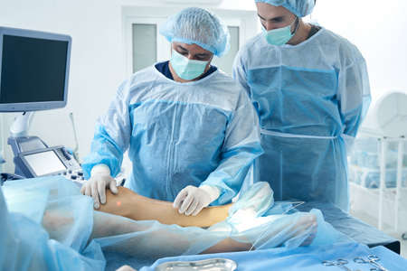 Phlebologists treating multifunctioning veins in the hospitalの写真素材