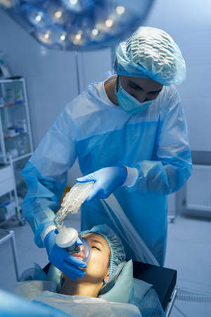 Medical worker maintaining general anesthesia before the surgery