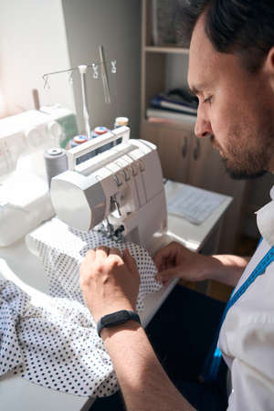 Tailor making clothes with polka dots with equipment