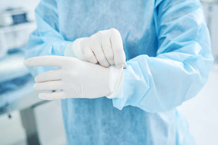 Unrecognized doctor in protective uniform preparing for surgeryの写真素材