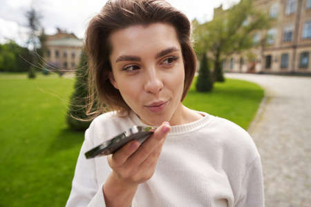 Young woman having phone conversation on the streetの写真素材