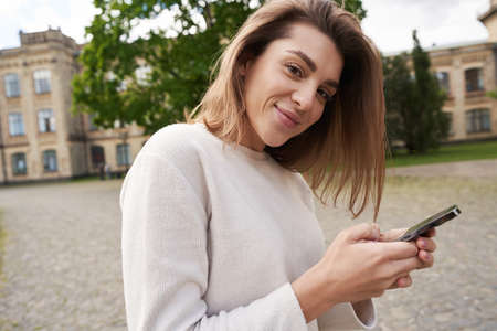 Young woman using smartphone on the street