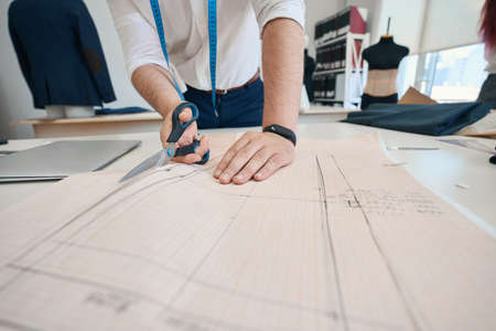 Male tailor making sketches of new clothesの写真素材