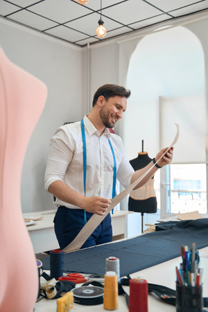 Man couturier examines the pattern of the sewing workshopの写真素材
