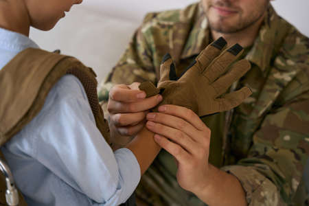 Caring father in military clasping glove on kid handの写真素材