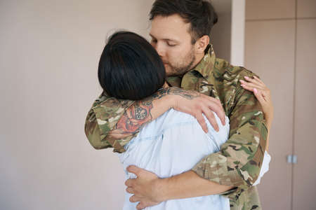 Wife embracing army man passionately before his departureの写真素材