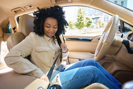 Beautiful mixed race woman is using a seat beltの写真素材
