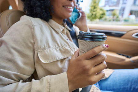 Multiracial woman talking on the phone in the carの写真素材