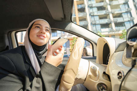 Young arab woman talking on the phone in the carの写真素材