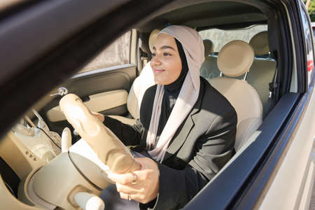 Arab woman in a headscarf drives a carの写真素材