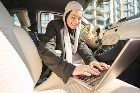 Young arab woman working in the car