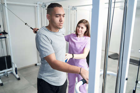 Doctor physiotherapist working with patient in rehabilitation clinicの写真素材