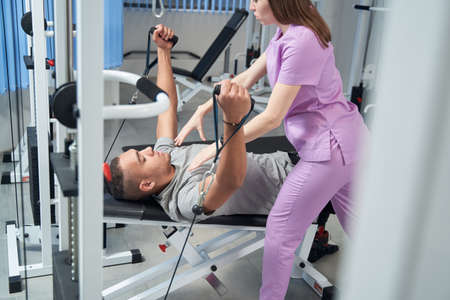 Man doing rehabilitation exercise with personal instructorの写真素材