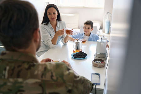 Happy young family chatting over morning tea