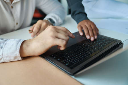 Close-up of hands of female and man working on keyboard