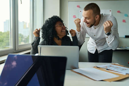 Managers at the computer rejoice at the promotion