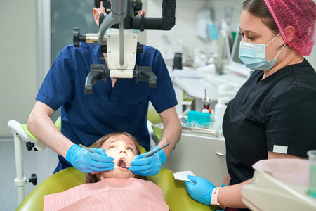 Pedodontist using modern diagnostic equipment during patient teeth examinationの写真素材