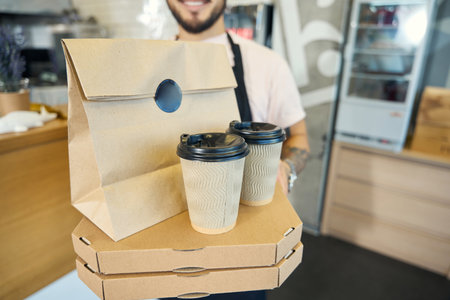 Ready-made boxes with takeaway pizza and drinks in barista handsの写真素材