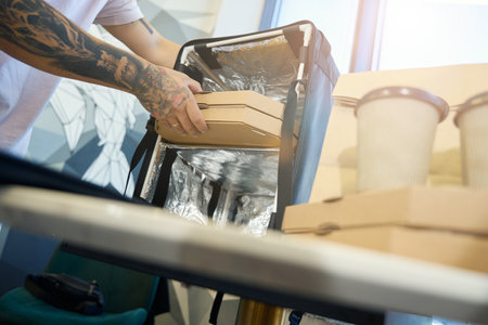 Responsible person preparing a special box for food delivery