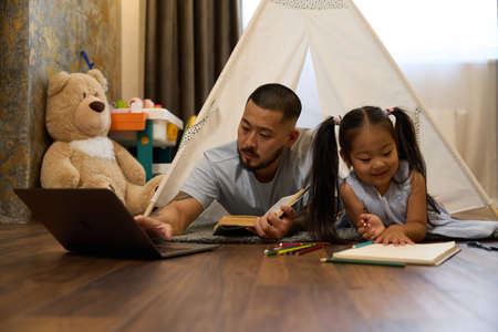 Father works from home and babysits little daughter