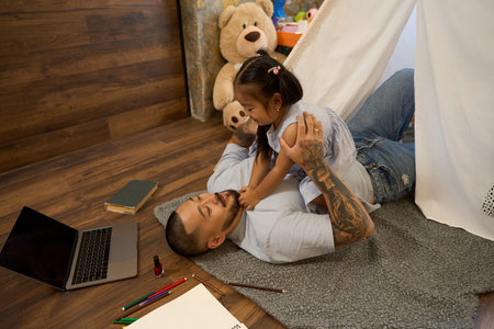 Father plays with his little daughter in a children hutの写真素材