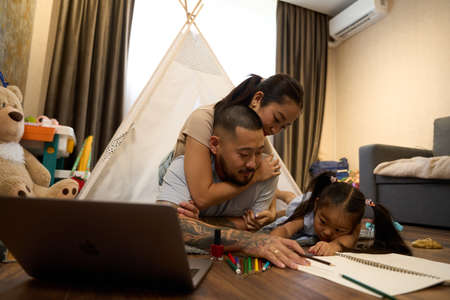Mom and dad help daughter color the picture