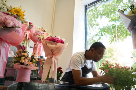 Young florist on the background of flowers and showcaseの写真素材