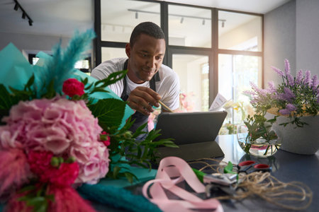 Florist in a black apron at the table makes calculations