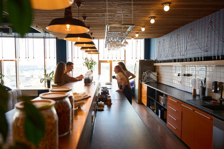 Three women and man gathered at the bar for communicationの写真素材